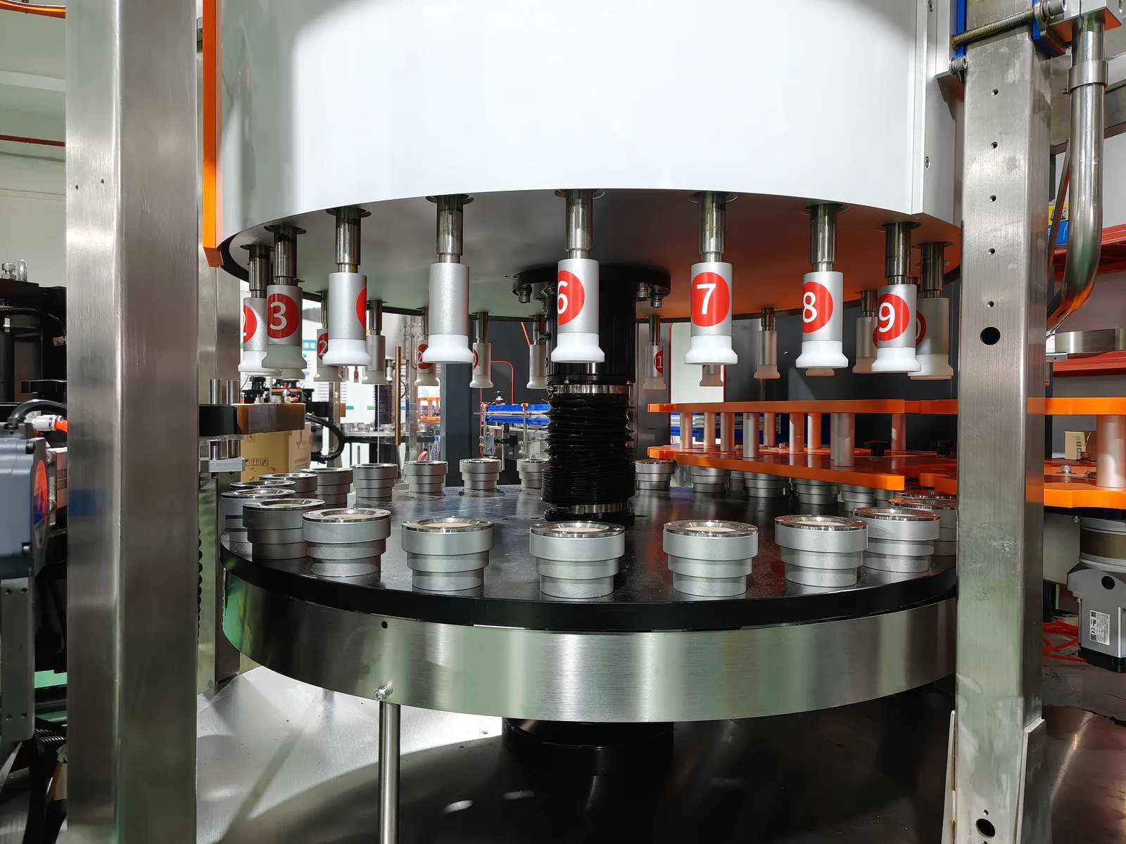 Rotary labeling machine turntable with numbered bottle-holder stations — station count, star-wheel tooling, and vision positioning are the specs that decide whether a machine fits a bottle line